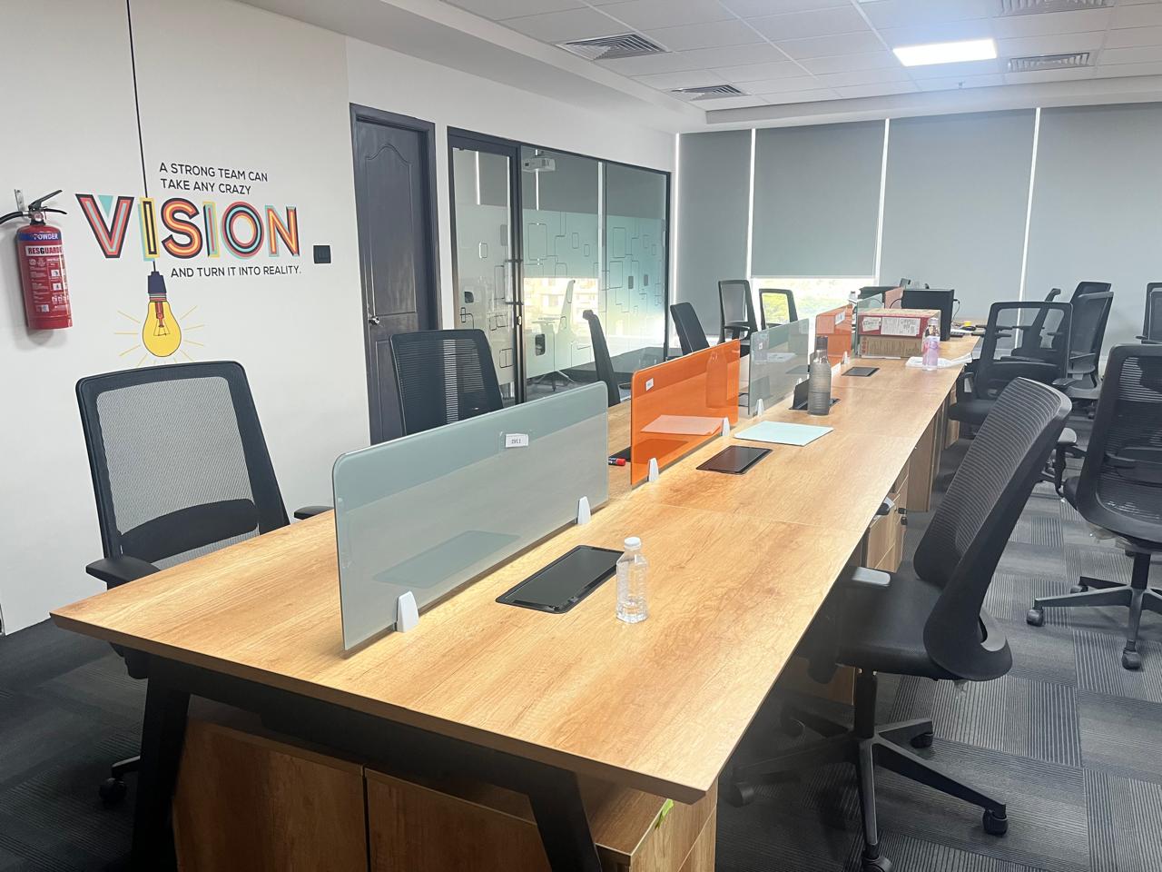 Open collaborative workspace with shared bench desks and partitions